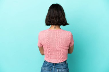 Genç melez kadın arka planda mavi arka planda izole edilmiş.