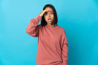 Mavi arka planda izole edilmiş genç Latin kadın bir şey fark etti ve çözüme niyetlendi.