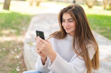 Cep telefonu kullanan güzel beyaz bir kadın.