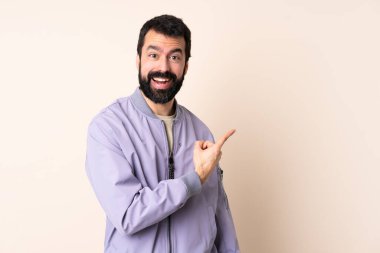 Sakallı, ceketli, soyutlanmış, şaşırmış ve işaret eden beyaz bir adam.