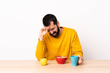 Kafkasyalı bir adam yorgun ve hasta bir ifadeyle kahvaltı yapıyor..