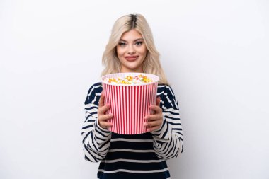 Beyaz arka planda izole edilmiş genç bir Rus kadın elinde koca bir kova patlamış mısır tutuyor.