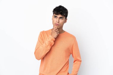 Young man over isolated white background thinking an idea while looking up