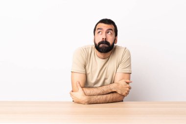 Masada sakallı, beyaz bir adamın yukarı bakarken şüpheleri var..