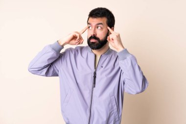 Sakallı, soyutlanmış arka planda ceket giyen beyaz bir adam. Şüpheleri ve düşünceleri var.