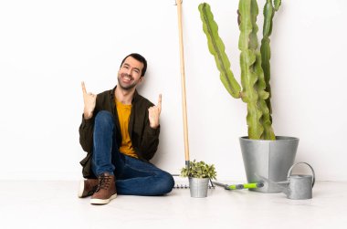 Bahçıvan yerde oturuyor ve harika bir fikri işaret ediyor.