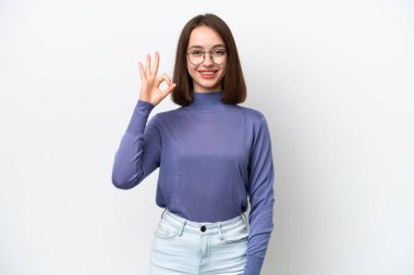 Beyaz arka planda izole edilmiş genç Ukraynalı kadın parmaklarıyla tamam işareti gösteriyor