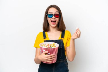 Genç Ukraynalı bir kadın beyaz arka planda gözlüklü ve elinde koca bir kova patlamış mısır tutuyor.