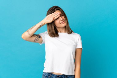 Genç Slovak kadın mavi arka planda izole edilmiş, yorgun ve hasta bir ifadeyle.