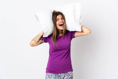 Genç Slovak kadın pijamalarıyla beyaz arka planda izole edilmiş ve yastığını tutarken bunalmış.