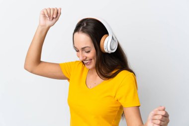 Genç İspanyol kadın soyutlanmış beyaz arka planda müzik ve dans dinliyor.