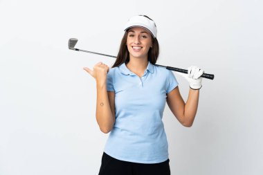 İzole edilmiş beyaz arka planda genç bir golfçü kadın bir ürünü sunmak için kenarı işaret ediyor.