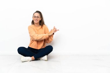 Yerde oturan genç kadın alkışlıyor