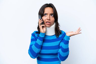 Boyunluk takan genç İspanyol kadın beyaz arka planda izole edilmiş cep telefonuyla sohbet ediyor.