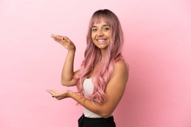 Pembe saçlı melez bir kadın. Pembe arka planda izole edilmiş. Kopyalama alanı tutuyor.