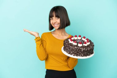 Doğumgünü pastası tutan melez bir kadın. Elinde bir ilan vermek için fotokopi makinesi var.