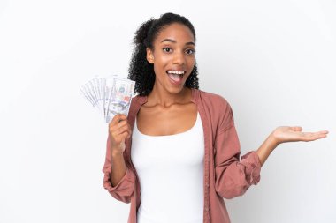 Genç Afrikalı Amerikalı bir kadın, beyaz arka planda izole edilmiş, şok olmuş bir yüz ifadesiyle bir sürü para alıyor.