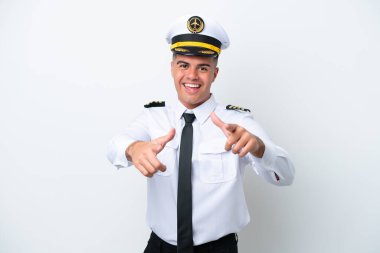 Uçak pilotu beyaz arka planda izole edilmiş beyaz bir adam önü işaret ediyor ve gülümsüyor.