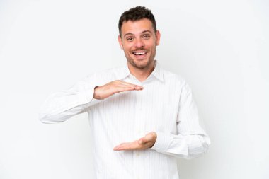 Beyaz arka planda izole edilmiş beyaz tenli yakışıklı bir adam, bir ilan vermek için avucunda hayali bir fotokopi makinesi tutuyor.