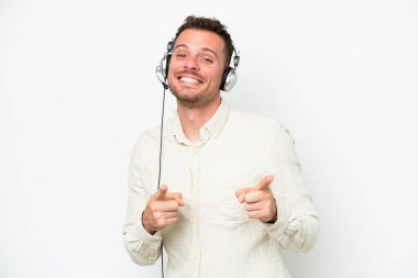 Tele pazarlamacı, beyaz arka planda izole edilmiş bir kulaklıkla çalışan beyaz bir adam ön tarafı işaret ediyor ve gülümsüyor.