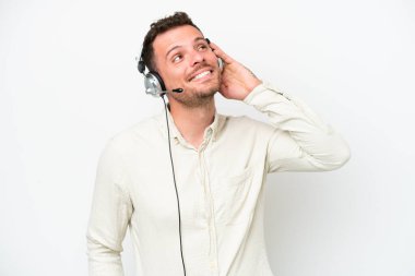 Beyaz arka planda izole edilmiş bir kulaklıkla çalışan beyaz pazarlamacı bir fikir düşünüyor.