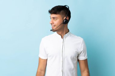 Kolombiyalı tele-pazarlamacı, arka planda izole edilmiş bir kulaklıkla çalışıyor.