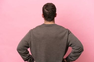 Kafkasyalı genç bir adam pembe arka planda izole edilmiş.