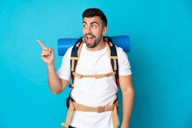 Genç dağcı mavi arka plan üzerinde bir parmak kaldırarak çözümü gerçekleştirmek niyetinde