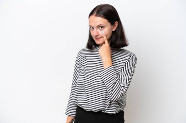 Beyaz arka planda izole edilmiş genç beyaz kadın bir şey gösteriyor.