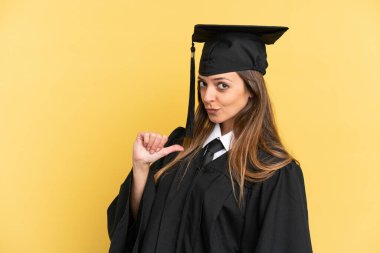 Sarı arka planda izole edilmiş genç üniversite mezunu gururlu ve kendini beğenmiş.