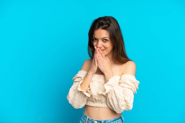 Genç beyaz kadın mavi arka planda izole edilmiş mutlu ve gülümseyen elleri ve ağzı kapalı.