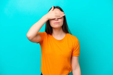 Mavi arka planda, gözleri elle kaplanmış beyaz bir kadın. Bir şey görmek istemiyorum.