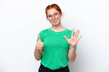 Beyaz arka planda izole edilmiş genç kızılımsı kadın parmaklarıyla altısını sayıyor