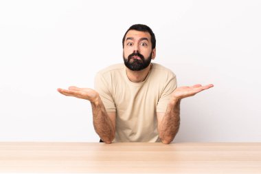 Masada sakallı, beyaz bir adam ellerini kaldırırken şüpheye düşüyor..