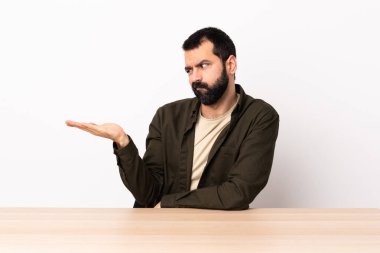 Masada sakallı beyaz bir adam. Kopyalama alanını şüphe ile tutuyor..