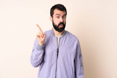 İzole edilmiş arka planda sakallı, beyaz bir adam parmağını kaldırarak çözümü bulmaya çalışıyor.