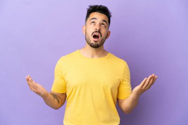 Mor arka planda izole edilmiş genç beyaz adam bunalıma girmiş.