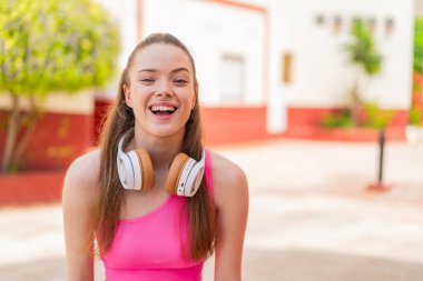 Açık havada, yüzünde sürpriz bir ifade olan genç ve güzel bir kız.