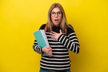 Sarı arka planda izole edilmiş genç bayan sağa bakarken şaşırmış ve şok olmuştu.