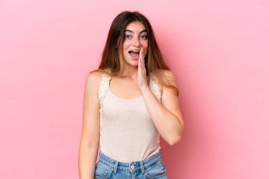 Pembe arka planda izole edilmiş beyaz bir kadın. Şaşırmış ve şok olmuş bir yüz ifadesi var.