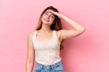 Pembe arka planda izole edilmiş beyaz bir kadın. Mutlu bir ifadeyle selamlıyor.