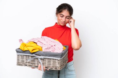 Beyaz arka planda izole edilmiş çamaşır sepeti tutan beyaz bir kadın hayal kırıklığına uğramış ve kulaklarını kapatmış.