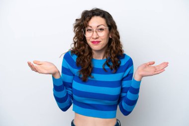 Beyaz arka planda izole edilmiş genç beyaz kadın ellerini kaldırırken şüpheleri var.