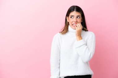 Pembe arka planda izole edilmiş genç bir İtalyan kadın biraz gergin.