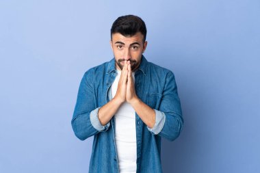 İzole edilmiş mavi geçmişi olan beyaz bir adam avuç içlerini bir arada tutar. İnsan bir şey ister.