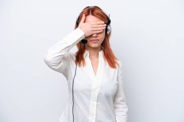 Tele pazarlamacı Rus kız kulaklıkla çalışıyor. Beyaz arka planda izole edilmiş, gözleri elle kapatıyor. Bir şey görmek istemiyorum.