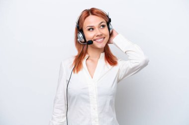 Tele pazarlamacı Rus kız beyaz arka planda izole edilmiş bir kulaklıkla çalışıyor.