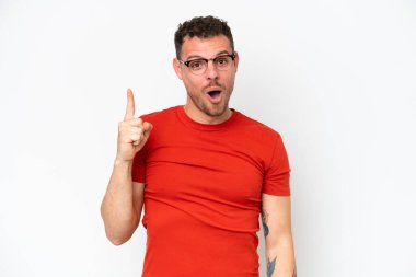 Beyaz arka planda soyutlanmış beyaz tenli yakışıklı bir adam çözümü bulmak için parmağını kaldırıyor.