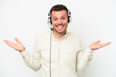 Tele pazarlamacı beyaz bir kulaklıkla çalışan beyaz yüzlü, şok olmuş bir adam.