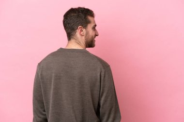 Kafkasyalı genç adam pembe arka planda izole edilmiş.